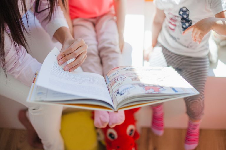 Imagen genérica: dos niñas leyendo un cuento con su madre. Imagen genérica: dos niñas leyendo un cuento con su madre.
