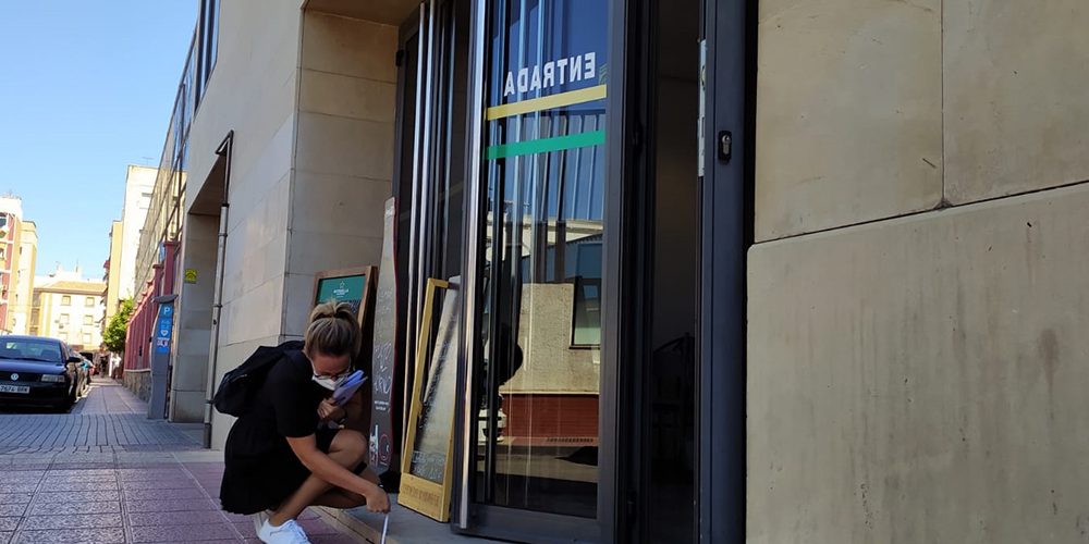 Técnico de Famdif midiendo la altura del escalón de entrada a una cafetería.