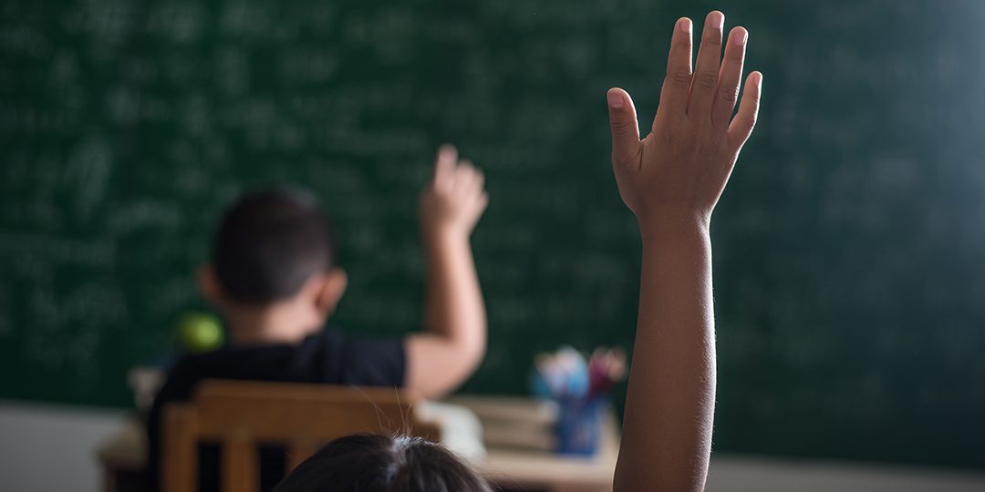 Foto genérica niños en el aula levantando la mano. Foto genérica niños en el aula levantando la mano.