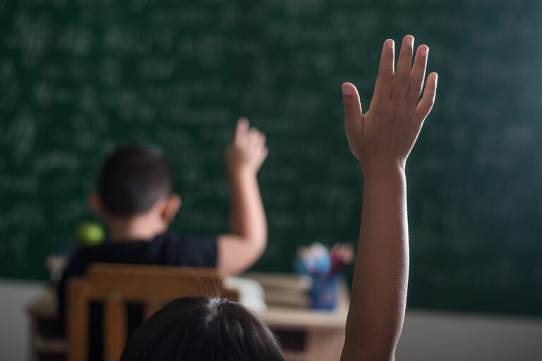 Foto genérica niños en el aula levantando la mano. Foto genérica niños en el aula levantando la mano.