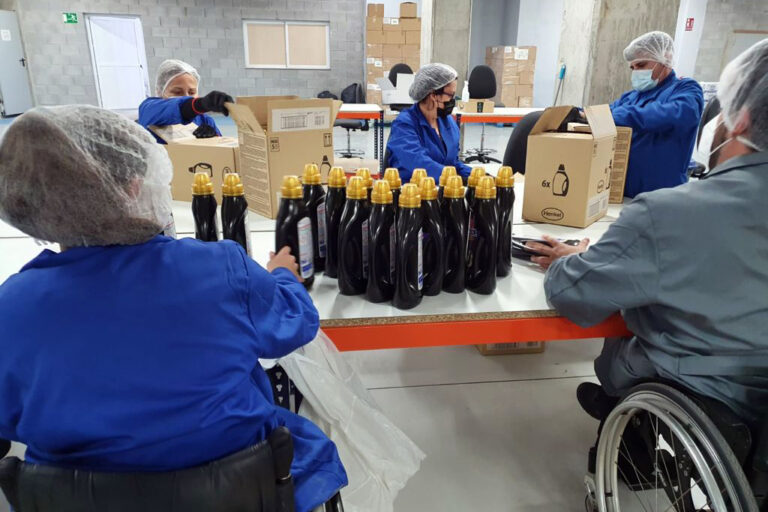 SERVIGEST Trabajadores de SERVIGEST manipulando botes sobre una mesa grande.