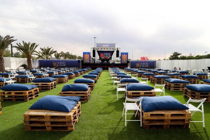 Foto de cabecera de la página de Facebook de las "Las noches del Malecón" donde se ve el espacio para sentarse y el escenario.